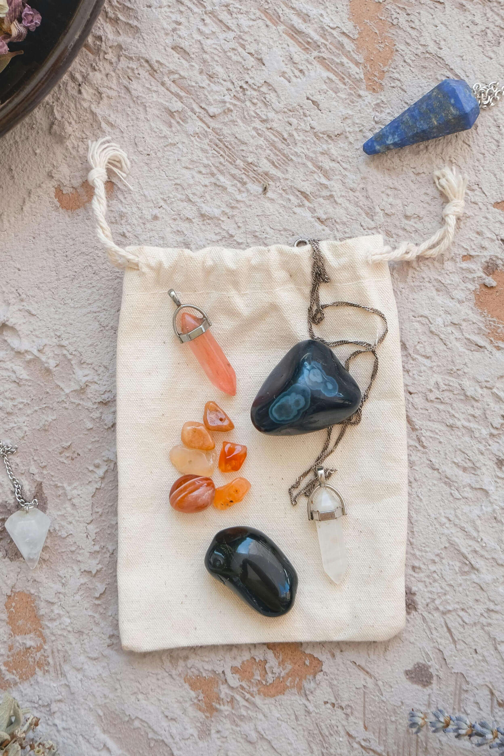 Photo of some crystals, crystal pendulums on a cloth bag.